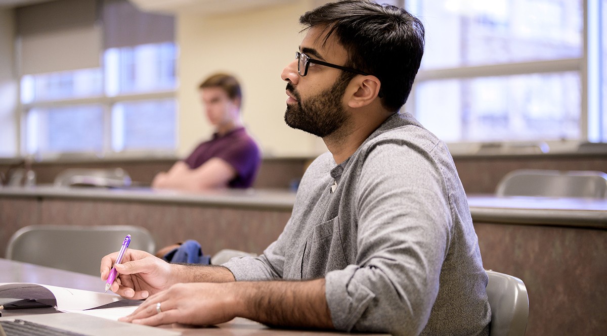 Graduate student taking notes in class