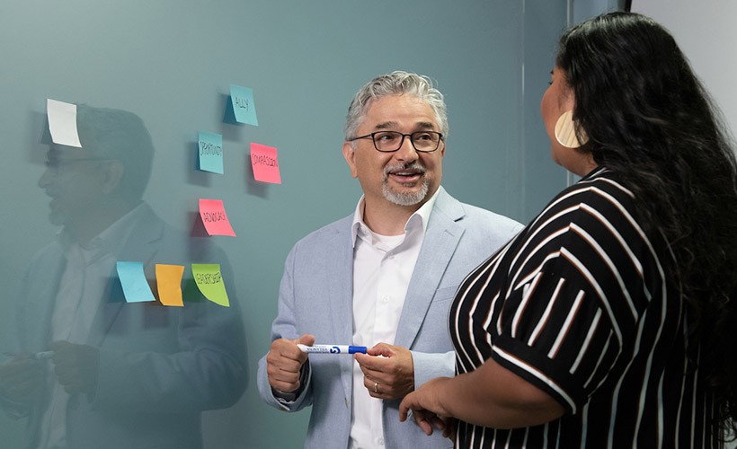 Edward Fierros, PhD, associate dean for UNITAS: Inclusive Education, talks with a student.