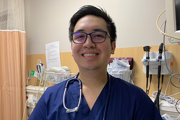 Jeremy Bonafe, graduate of the BSNExpress program, stands in a hospital room.