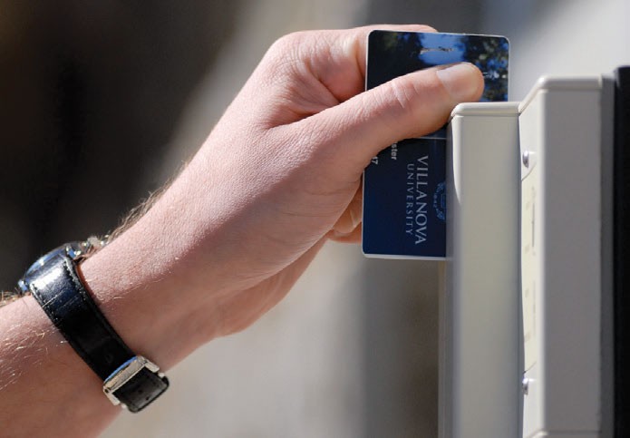 A hand swiping a wildcard for access into a building