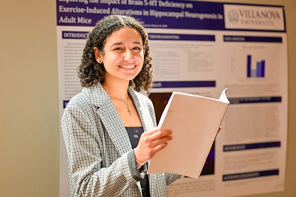 Female student reading book and smiling