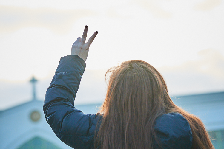 student standing with V up