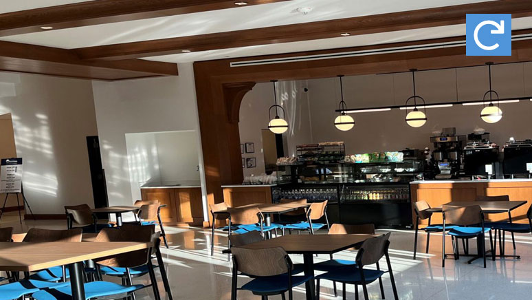 Several people are at the register in cafeteria.