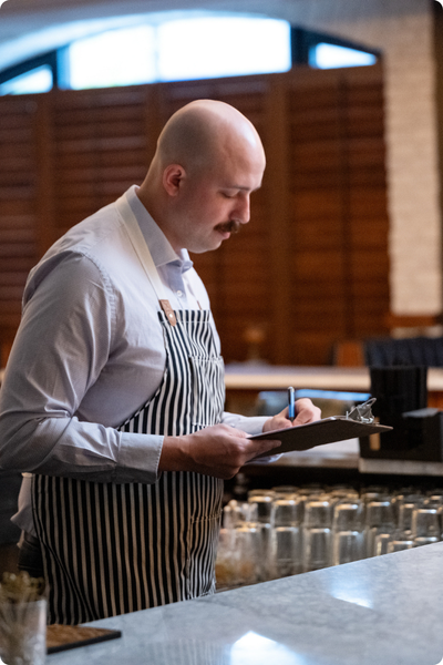 man on ipad behind a bar